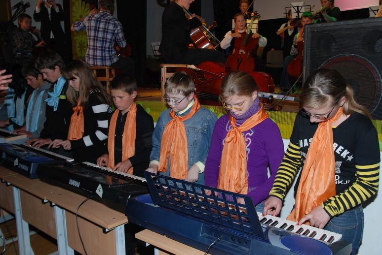 row of keyboard players in concert
