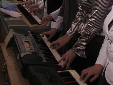 fingers of a long row of keyboard players