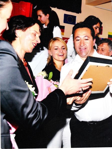 happily laughing people crowding, looking at a picture at interculturla meeting