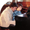 teacher and pupil playing piano together
